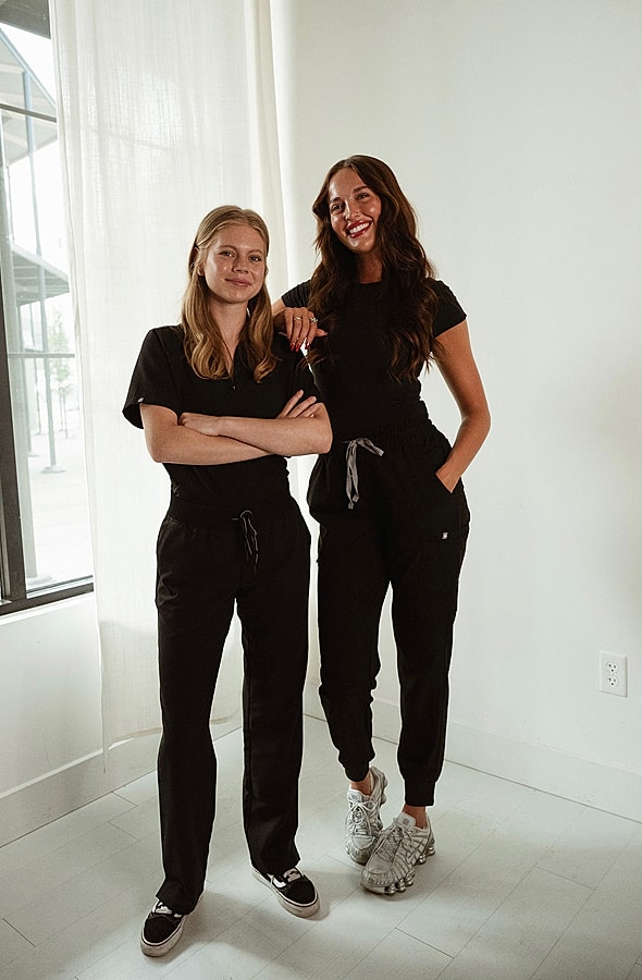 Smiling woman with long hair in black top.