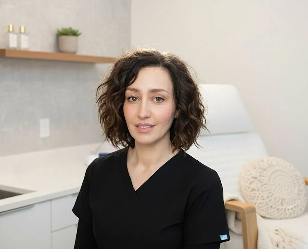 Smiling woman with long hair in black top.