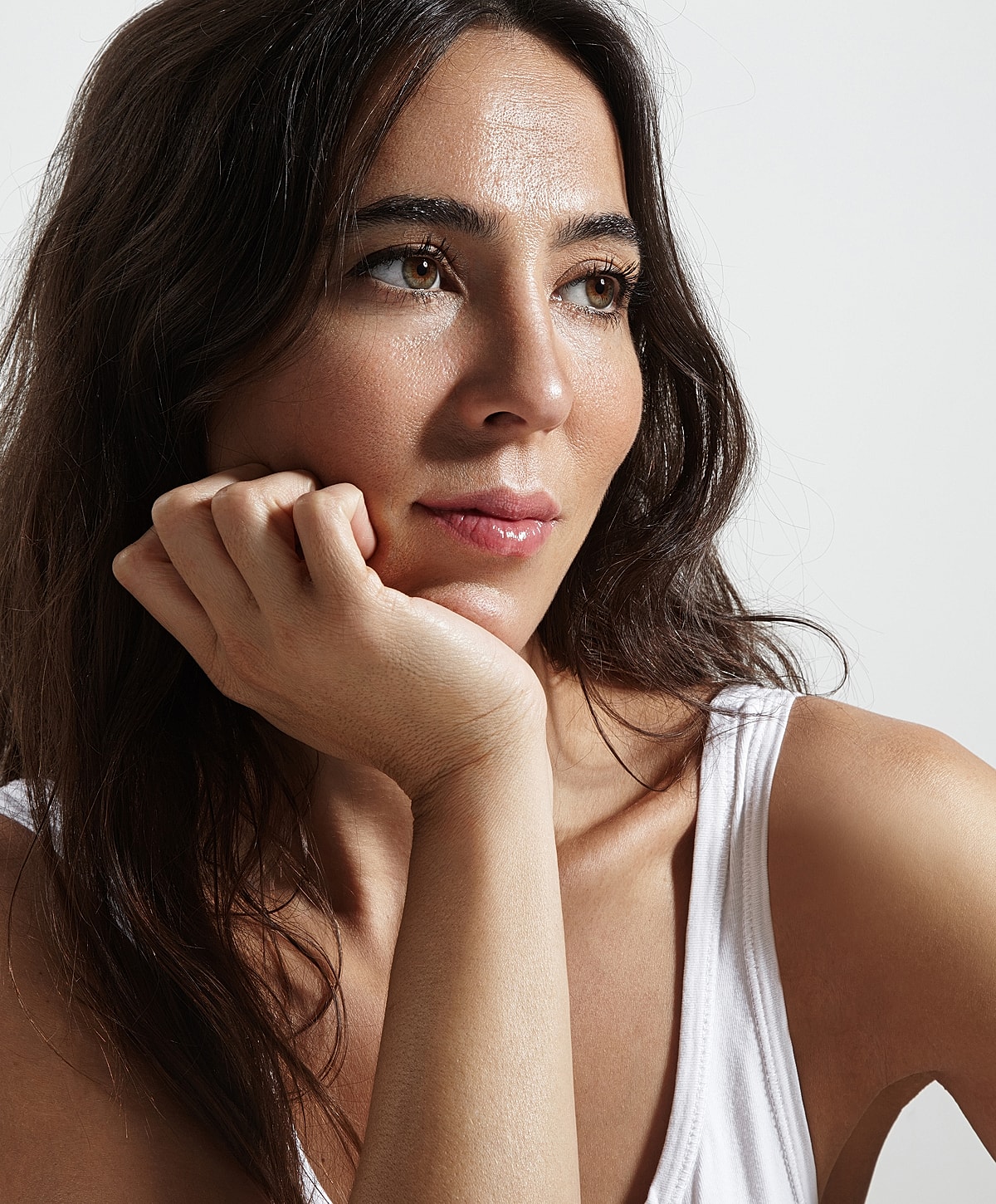 Model posing with hands raised and closed eyes.