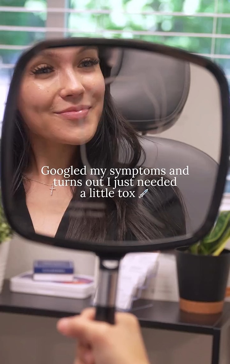 Woman smiling in mirror at a doctor's office.
