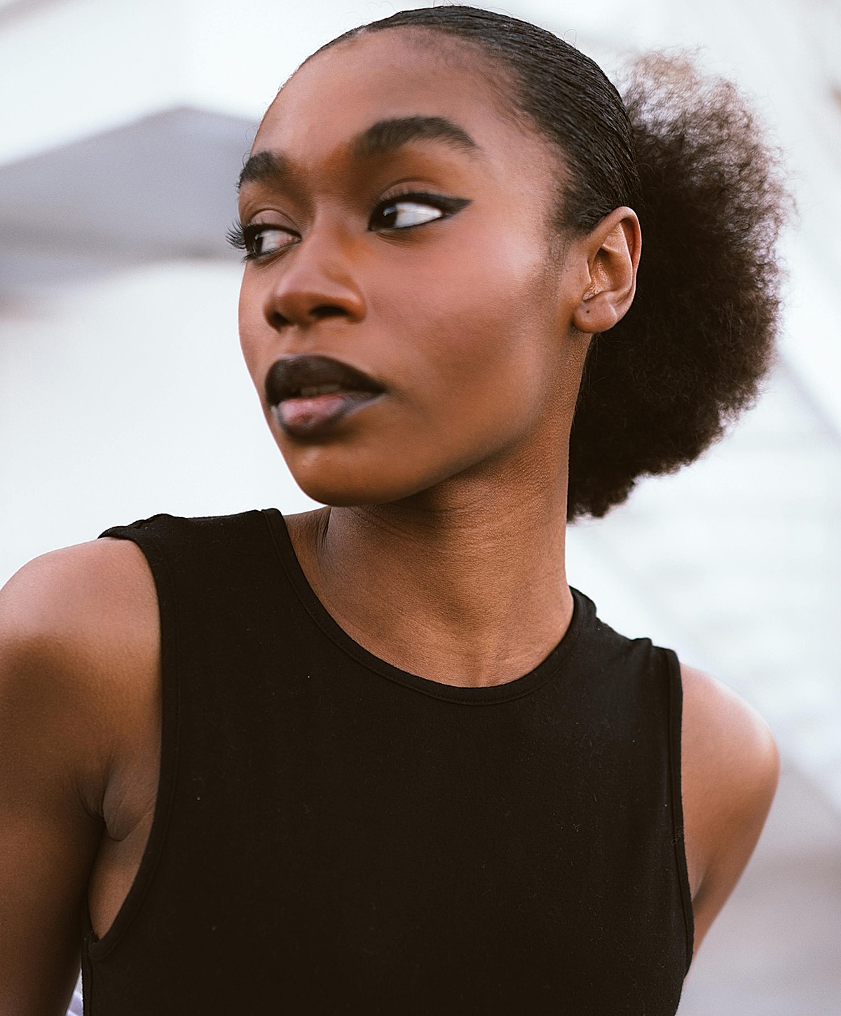 Model posing with hands raised and closed eyes.