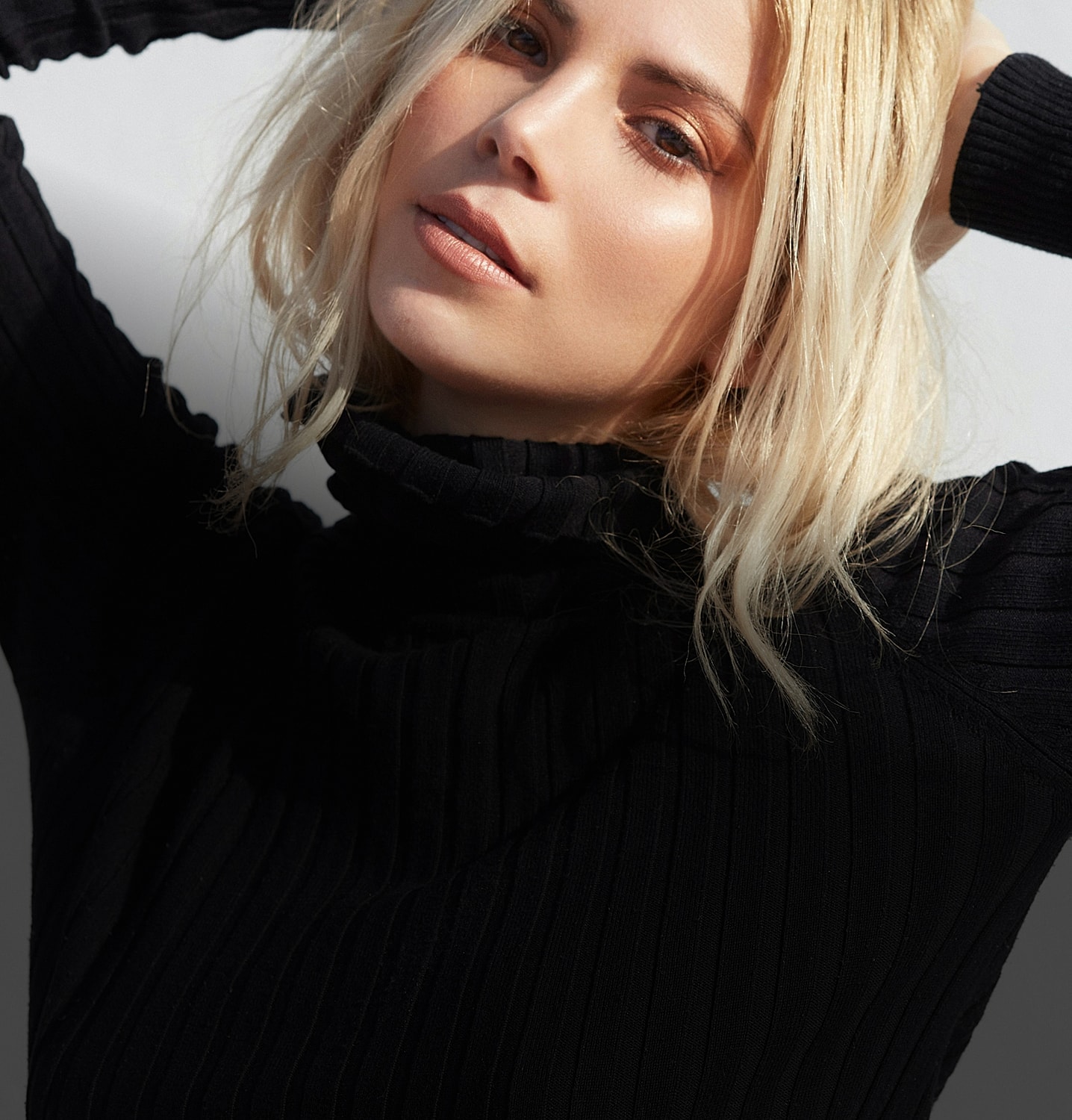 Young woman with radiant skin and patterned clothing.